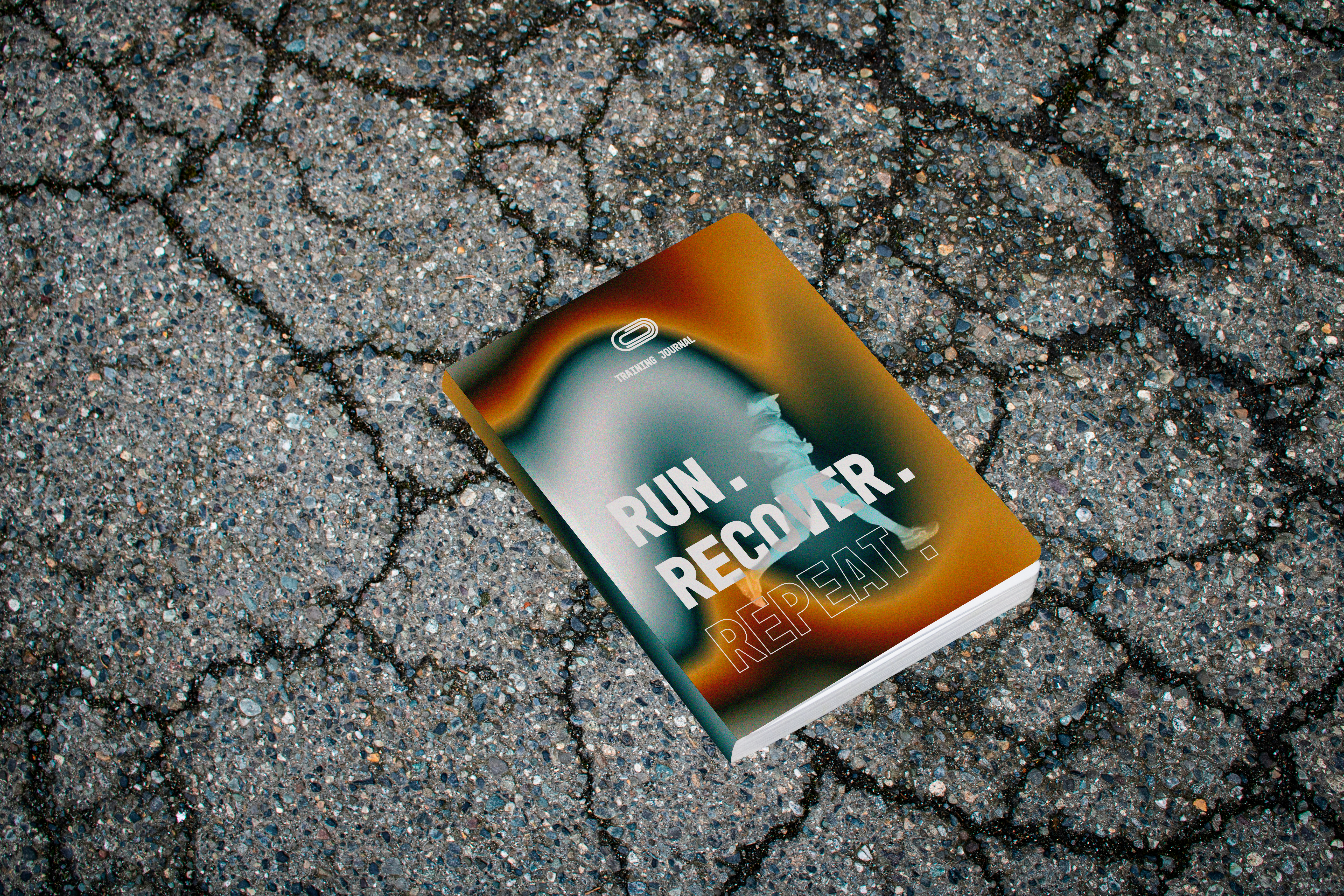 Run. Recover. Repeat. training journal lying on a running track